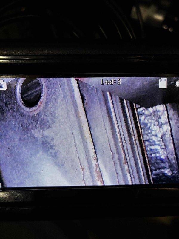 Performed a heating-season tune-up, including a borescope inspection of the heat exchanger cavity that revealed surface rust and accumulated debris on the fins and surrounding surfaces. Inspected the humidifier evaporator pad and found heavy mineral scale buildup and rust staining, indicating the pad is due for cleaning or replacement. Performed a heating-season tune-up, including a borescope inspection of the heat exchanger cavity that revealed surface rust and accumulated debris on the fins and surrounding surfaces. Inspected the humidifier evaporator pad and found heavy mineral scale buildup and rust staining, indicating the pad is due for cleaning or replacement.