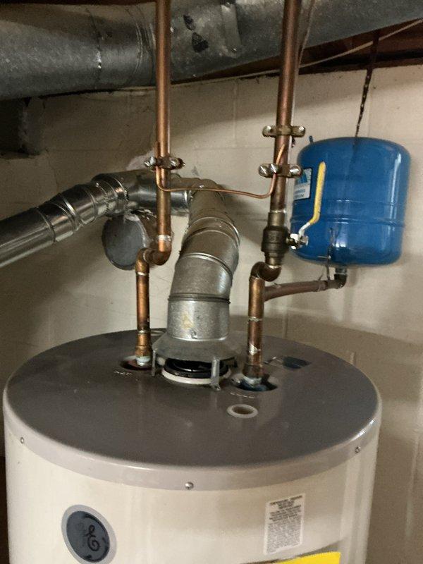 Performed a courtesy plumbing inspection of the natural gas water heater, including the temperature and pressure relief valve with copper discharge line, the copper supply piping and brass shut-off valve, the thermal expansion tank, and the galvanized flue vent connection at the draft hood. Components were found in place and properly configured, with light patina and residue noted at copper joints but no active leaks observed. Performed a courtesy plumbing inspection of the natural gas water heater, including the temperature and pressure relief valve with copper discharge line, the copper supply piping and brass shut-off valve, the thermal expansion tank, and the galvanized flue vent connection at the draft hood. Components were found in place and properly configured, with light patina and residue noted at copper joints but no active leaks observed.