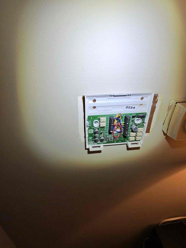 Removed the existing round dial thermostat and replaced it with a new wall-mounted thermostat. Disconnected and labeled the low-voltage control wiring (R, Y, and others) at the terminal block, then reconnected them to the new base plate and mounted it securely to the wall. Verified proper terminal connections and system operation following installation. Removed the existing round dial thermostat and replaced it with a new wall-mounted thermostat. Disconnected and labeled the low-voltage control wiring (R, Y, and others) at the terminal block, then reconnected them to the new base plate and mounted it securely to the wall. Verified proper terminal connections and system operation following installation.