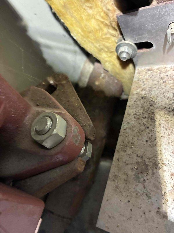 Responded to a reported boiler leak and inspected the unit's interior components, piping, and mounting hardware. Observed heavy surface rust and corrosion on the steel mounting plate, fittings, and piping, along with worn, scuffed paint and accumulated dust and cobwebs within the equipment area. Documented the conditions photographically to support leak source identification and further corrective action. Responded to a reported boiler leak and inspected the unit's interior components, piping, and mounting hardware. Observed heavy surface rust and corrosion on the steel mounting plate, fittings, and piping, along with worn, scuffed paint and accumulated dust and cobwebs within the equipment area. Documented the conditions photographically to support leak source identification and further corrective action.