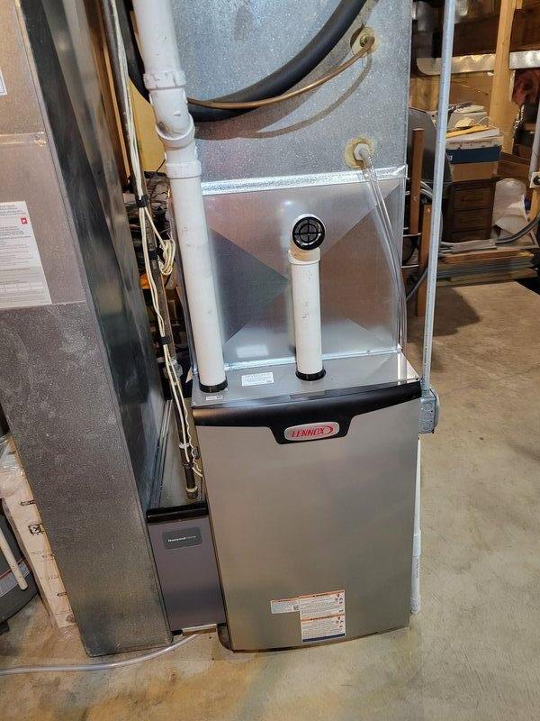 Successfully completed installation of Lennox EL297E 90K furnace with built-in K-furnace sensor. Properly mounted unit on platform, connected intake/exhaust PVC venting, and integrated with existing ductwork system and thermostat. System is now operational with proper connections to all necessary infrastructure.