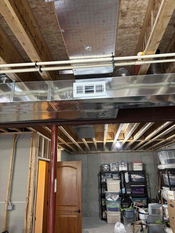 Installed two additional supply runs in unfinished basement area and mounted corresponding supply registers. Located optimal positioning around existing HVAC ductwork and completed installation while navigating exposed ceiling joists, PVC piping, and structural elements. Both supply registers are now properly functioning and integrated with the main duct system.