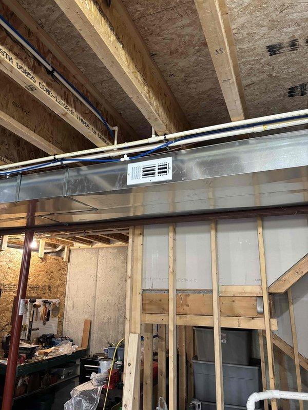 Installed two additional supply runs in unfinished basement area and mounted corresponding supply registers. Located optimal positioning around existing HVAC ductwork and completed installation while navigating exposed ceiling joists, PVC piping, and structural elements. Both supply registers are now properly functioning and integrated with the main duct system.