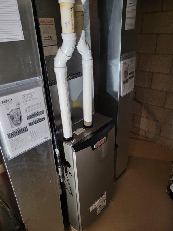 Successfully completed installation of two Lennox EL297E 70K BTU furnaces in basement utility room. Installation included new media cabinets while reusing existing compatible return ducts. Proper venting was established with PVC intake and exhaust pipes. Both units were installed to manufacturer specifications and are functioning optimally.