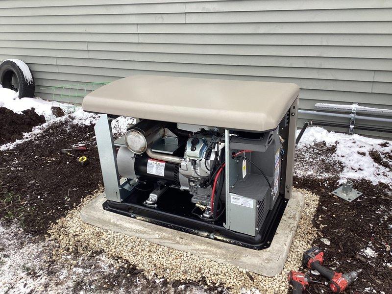 Successfully installed a 20KW Kohler Air-cooled Home Standby Generator (model 20RCA) with aluminum cabinet and 200AMP service-rated automatic transfer switch for whole-house backup power. Set generator on prepared concrete pad with gravel surround after ground thawing, completed all necessary low/line voltage wiring, and installed gas pipe with connections and exterior gray oil-based paint finish. System includes battery, carburetor heater, and oil heater with proper grounding and bonding.