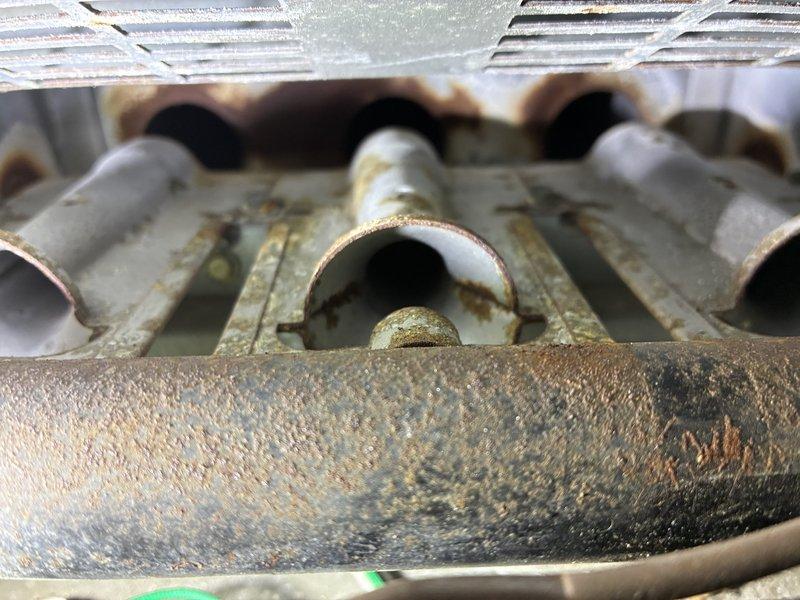 Responded to no heat call on aging system (10+ years). Inspection revealed severely corroded heat exchanger with significant rust buildup and mineral deposits on burner components. Performed comprehensive cleaning of system components as sold by Dave under CCC service. Unit successfully restored to proper heating operation.