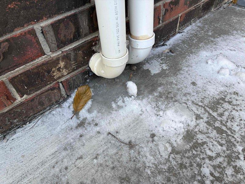 Identified and repaired improper fittings on furnace PVC exhaust piping that was causing condensation buildup on concrete surface. Installed proper drainage fittings on exterior vent pipes to ensure appropriate condensate removal and prevent potential blockage issues.