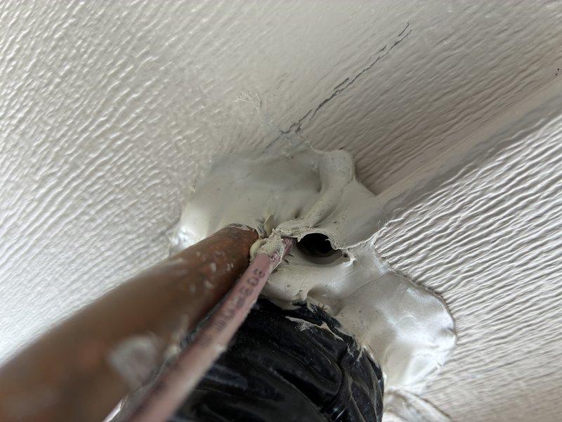 Inspected leaking copper refrigerant line running between furnace and AC unit. Identified condensation issue on the line set originating from the exterior. Advised customer to contact their contractor/siding company to properly seal around penetrations with color-matched caulking to prevent moisture infiltration.