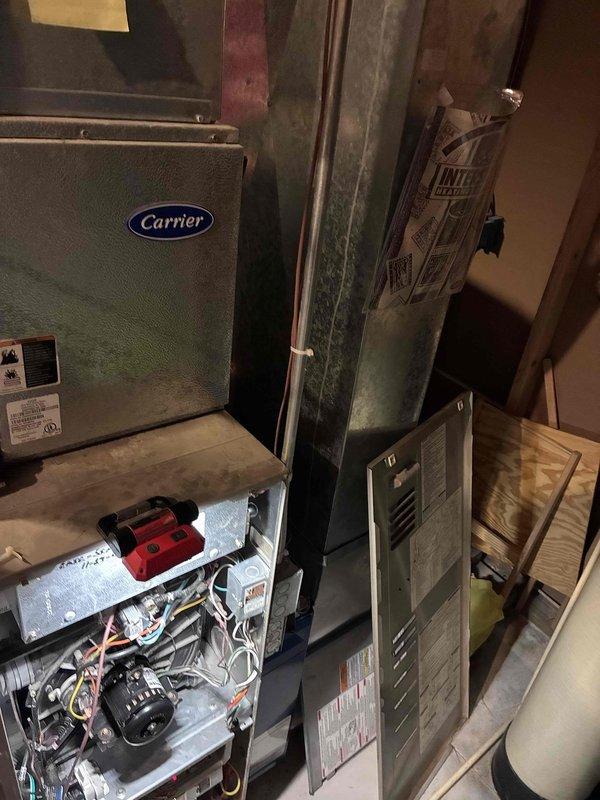 Responded to emergency no-heat call for Carrier furnace over 10 years old. Diagnostic inspection revealed failed heat exchanger and failing inducer/exhaust motor, with customer utilizing temporary box fan solution prior to arrival. Presented equipment replacement options due to age of unit and extent of critical component failures.