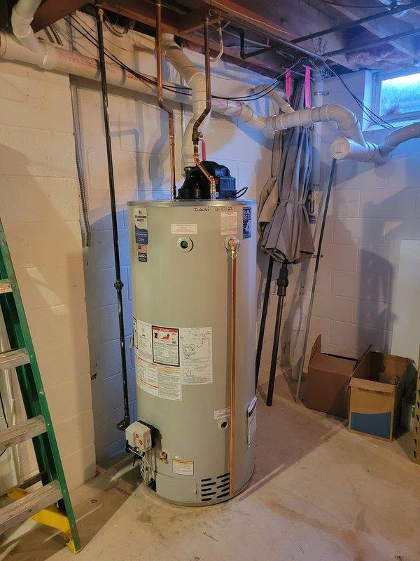 Successfully installed a new 75-gallon power vent water heater in basement utility room, replacing an existing smaller unit. Job required non-standard installation configuration with additional PVC venting and copper pipe connections to integrate with the existing plumbing system. Electrical work coordinated for outlet installation to power the new unit.
