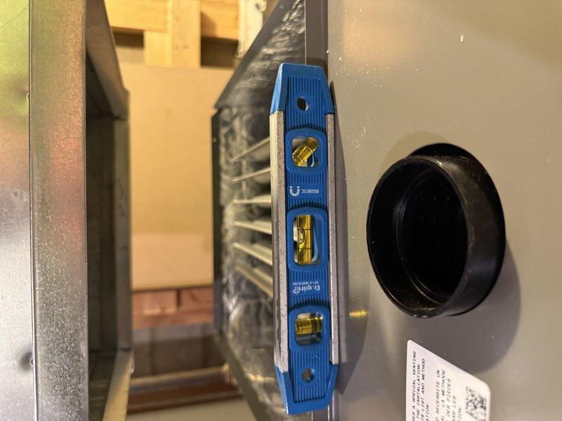 Completed installation of EL297V 70K Furnace and AA 600 air conditioning system, ensuring proper leveling and ductwork connections. Visual inspection confirmed correct mounting and alignment of all components in the basement/crawlspace area, with particular attention to secure ductwork joints and proper electrical connections.