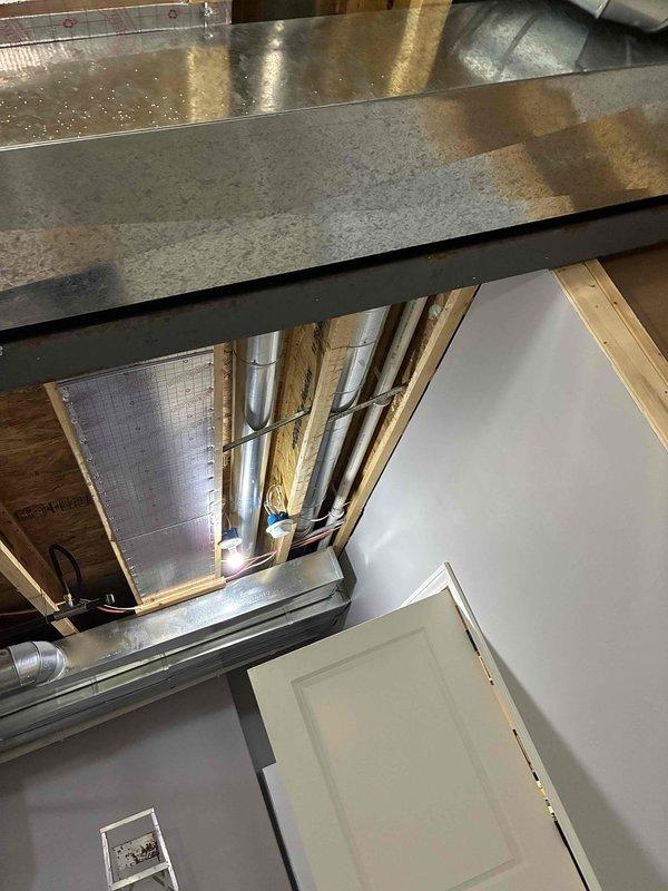 Performed 10-point furnace tune-up and inspected problematic zoning system. Observed metal ventilation ducting with protective grill showing minor dust accumulation. Inspected newly installed metal ductwork in unfinished space with exposed ceiling infrastructure. Assessment completed for potential zoning repair requirements.