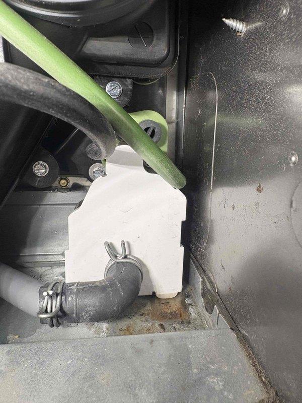 Oconomowoc, WI - Responded to customer callback regarding water on floor discovered after returning from vacation. Inspection revealed condensate drain line connection issue with visible corrosion and mineral deposits at the gray elbow pipe junction. Secured drain connection with metal clamp and verified proper drainage to prevent future leakage. Oconomowoc, WI - Responded to customer callback regarding water on floor discovered after returning from vacation. Inspection revealed condensate drain line connection issue with visible corrosion and mineral deposits at the gray elbow pipe junction. Secured drain connection with metal clamp and verified proper drainage to prevent future leakage.