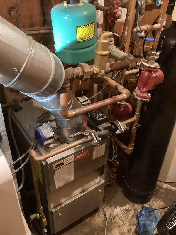 Conducted initial assessment of high-risk system consisting of a 1978 water-jacketed fireplace connected to 30+ year-old boiler. Observed significant gurgling in the hydronic wood stove and documented pressure gauge readings on brick mounting. Inspected expansion tank, valves, and copper piping network showing signs of deterioration. Relief valve repeatedly activating during operation. Advised customer against using the fireplace component and recommended obtaining quote for complete system replacement due to critical safety concerns.