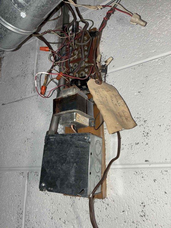 Conducted initial inspection of commercial boiler system in response to new maintenance agreement setup. Examined control circuitry including PCB connections and wiring harness inside access panel. Noted aged electrical assembly mounted on cinderblock wall with exposed wiring connections requiring attention. Documented system condition with photographs for baseline assessment. No service history available despite existing company identification sticker on unit.
