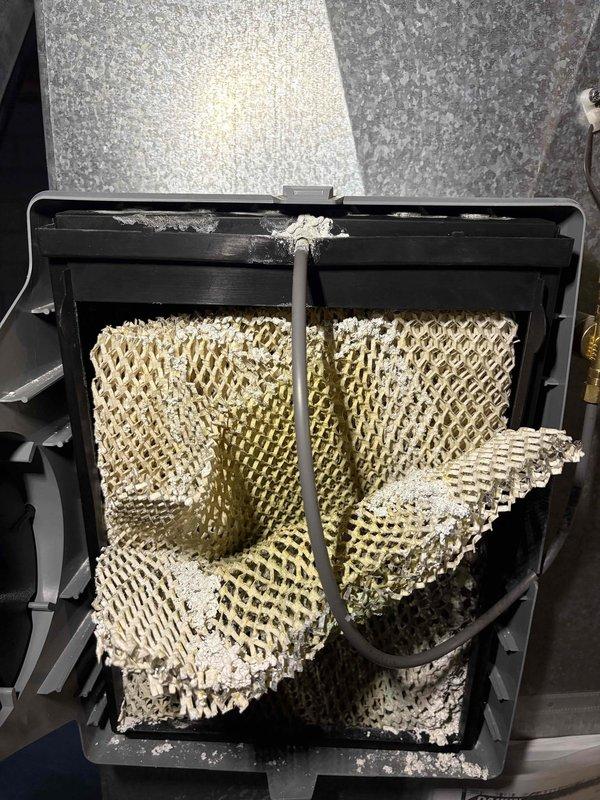 Completed furnace tune-up with filter replacement and comprehensive humidifier service, which included cleaning the severely scaled evaporative pad and rewiring the unit to restore functionality. Identified deteriorated burner assembly requiring replacement and addressed loud operating noise. Recommended replacement of burners to prevent future system inefficiency and potential failure.