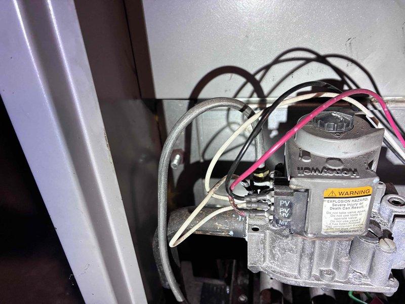 Responded to no heat complaint on aging steam boiler system. Diagnosed electrical fault in control circuit - found and repaired shorted wiring affecting ignition sequence. Cleaned Pressuretrol pigtail to restore proper pressure monitoring (gauge reading approximately 25 PSI). System now functioning correctly with proper ignition.