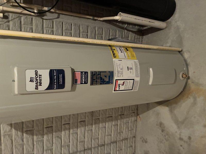 Replaced failed, leaking water heater with new 50-gallon electric Bradford White model. Completed full installation including proper pipe connections and insulation. Applied extended warranty sticker and documented model/serial numbers for warranty registration.