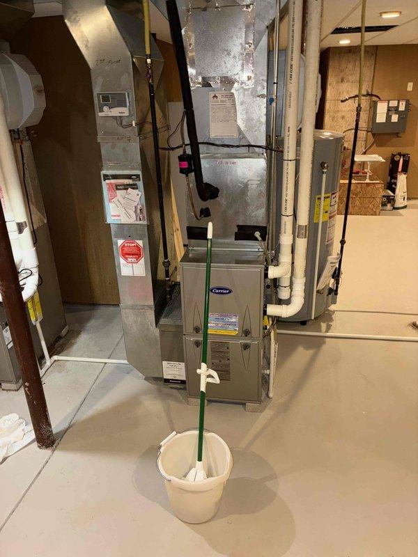 Responded to callback for water accumulation under first floor HVAC unit. Inspected the Carrier furnace system and associated Aprilaire whole-home humidifier. Identified and corrected drainage issue from humidifier that was causing water pooling. Cleaned affected area and verified proper system operation.