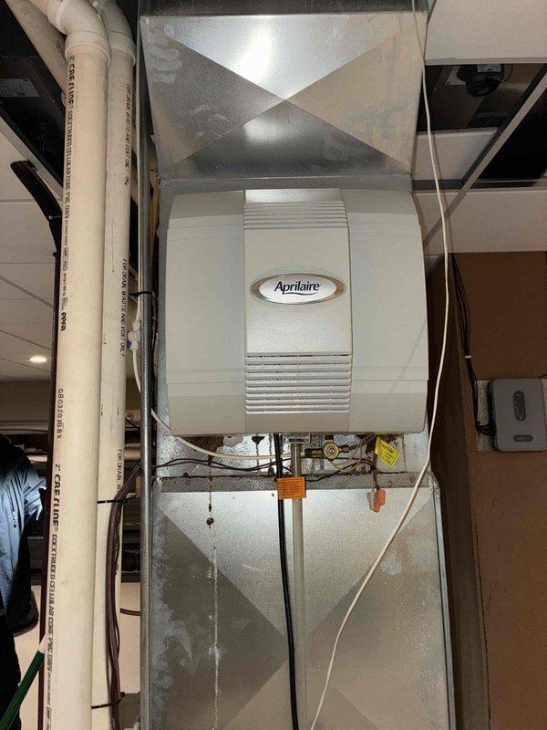 Responded to callback for water accumulation under first floor HVAC unit. Inspected the Carrier furnace system and associated Aprilaire whole-home humidifier. Identified and corrected drainage issue from humidifier that was causing water pooling. Cleaned affected area and verified proper system operation.