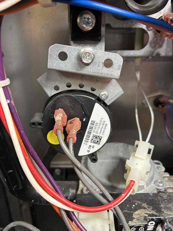 Replaced faulty pressure switches in HVAC system with new components. Installation included proper reconnection of all electrical wiring (red, yellow, blue, and white wires) to the new switches mounted on the metal bracket. System tested and returned to normal operating condition.