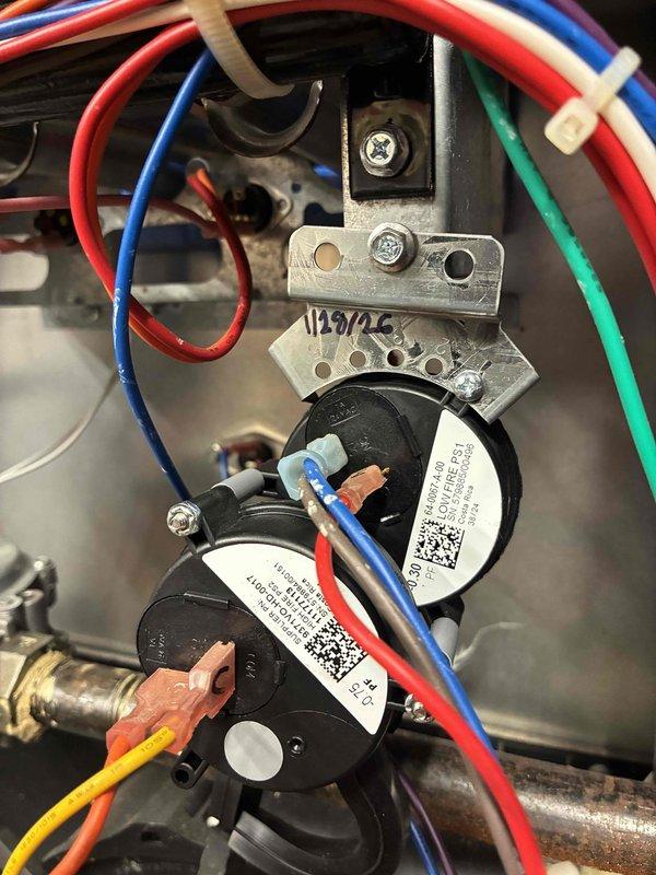 Replaced faulty pressure switches in HVAC system with new components. Installation included proper reconnection of all electrical wiring (red, yellow, blue, and white wires) to the new switches mounted on the metal bracket. System tested and returned to normal operating condition.