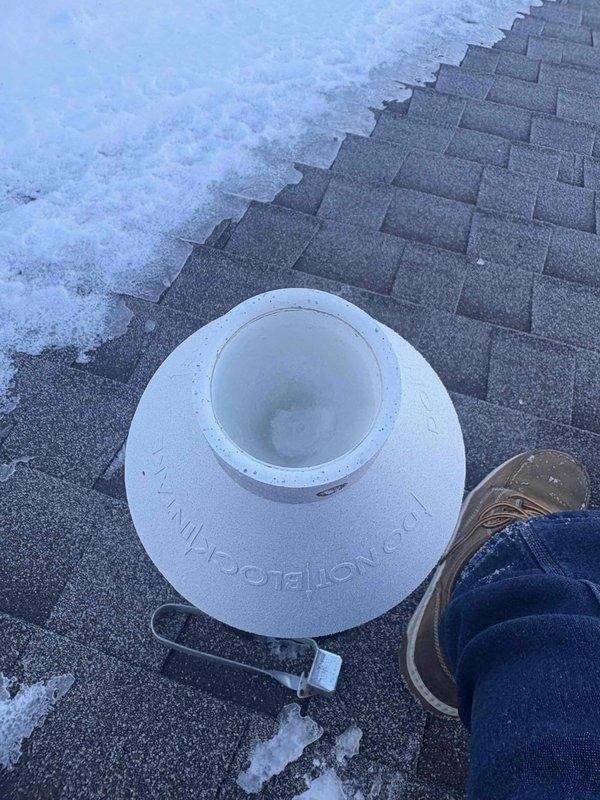 Responded to no heat service call at customer's newly purchased residence. Diagnosed frozen condensate flue pipe on roof, which was causing system shutdown. Accessed roof, thawed blocked vent pipe, and restored proper exhaust flow. Also replaced air filter to improve system efficiency. Customer was educated about common freeze-up issues with this system configuration and preventive measures.