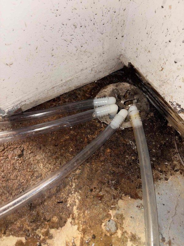 Responded to customer complaint about water leakage after extended absence. Inspected humidifier unit mounted on ductwork and identified disconnected drainage tubes in basement utility area. Observed significant moisture damage and potential mold growth on walls near the drainage system. Reconnected and secured all drainage lines to prevent future leakage.