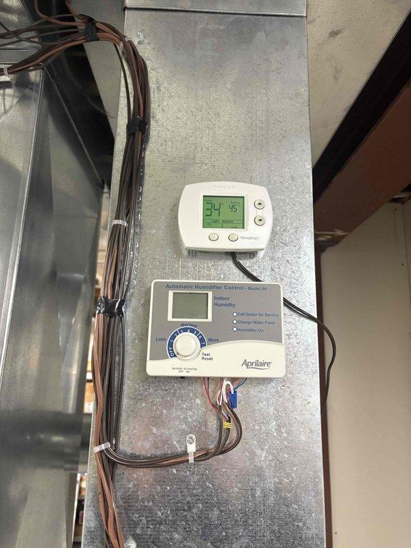 Responded to service call for leaking Aprilaire humidifier located in mechanical room. Identified water leakage issue from drain hose connection and determined humidifier tray needs replacement. Temporarily secured drain hose connection and ordered necessary replacement parts for permanent repair.