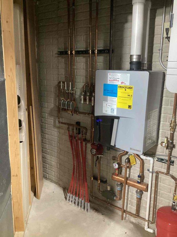 Responded to service call for Rinnai on-demand water heater/boiler system with no pressure to basement in-floor heating. Diagnostic revealed clogged flow sensor and air trapped in the heating loops. Performed system maintenance by flushing flow sensor and bleeding air from lines to restore proper operation.