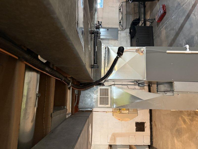 Completed installation of a 3-ton Lennox EL15KC1 air conditioning system in utility area with proper ductwork connections. System was fully installed with insulated refrigerant lines and appropriate mechanical connections to existing infrastructure. Final inspection confirmed proper operation with no outstanding issues.