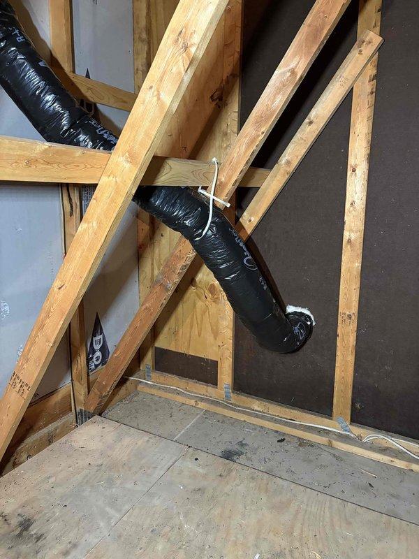 Completed installation of bathroom ventilation system by removing existing silver vent duct in garage attic and replacing with properly secured insulated flex duct. Rerouted ventilation to terminate through the garage gable wall, eliminating ceiling termination, with all ductwork properly fastened to structural framing members.