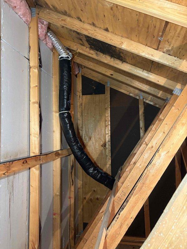 Completed installation of bathroom ventilation system by removing existing silver vent duct in garage attic and replacing with properly secured insulated flex duct. Rerouted ventilation to terminate through the garage gable wall, eliminating ceiling termination, with all ductwork properly fastened to structural framing members.