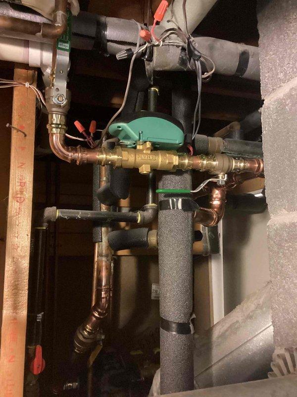 Completed boiler system repairs including replacement of three zone valves with new isolation ball valves, replacement of air eliminator head, correction of improperly installed pump orientation, and re-piping of basement zone for improved accessibility. System was refilled and all loops were bled to restore proper operation.
