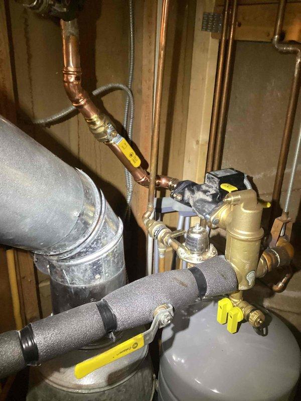 Completed boiler system repairs including replacement of three zone valves with new isolation ball valves, replacement of air eliminator head, correction of improperly installed pump orientation, and re-piping of basement zone for improved accessibility. System was refilled and all loops were bled to restore proper operation.