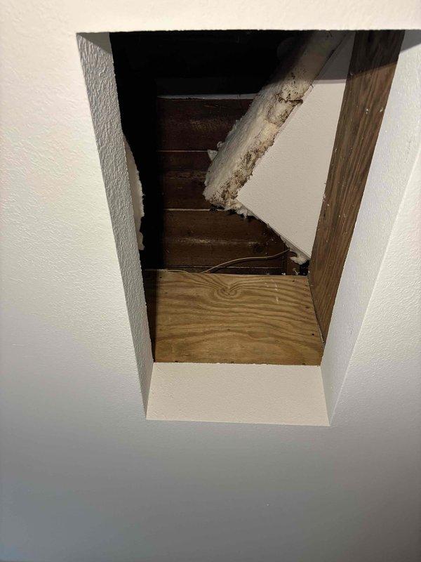 Performed inspection of attic furnace and identified insufficient combustion air supply. Documented inadequate fresh air intake with photos showing compressed insulation around ductwork and the attic access point. Recommended installation of fresh air baffles by a qualified roofing contractor to resolve the ventilation deficiency.