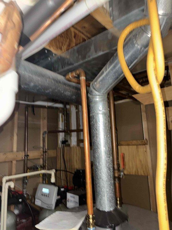 Performed annual maintenance agreement service on furnace system and April Aire humidifier, including filter and water panel replacement as requested by customer. Inspected ductwork and HVAC components in mechanical room, noting inadequate heating/cooling to room above garage due to thermostat placement issues. Discussed potential zoning options to resolve temperature distribution problems and collected payment on-site as required.