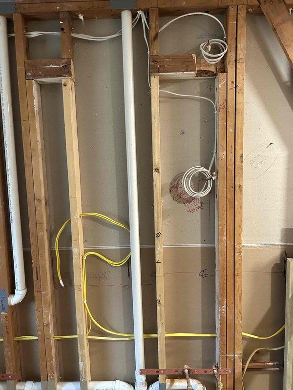 Completed rough-in electrical installation for bathroom remodel, including running new wiring through wall framing for fixtures and outlets. Installed electrical boxes and routed yellow and white cables through studs according to code requirements, coordinating placement with plumbing infrastructure prior to drywall completion.