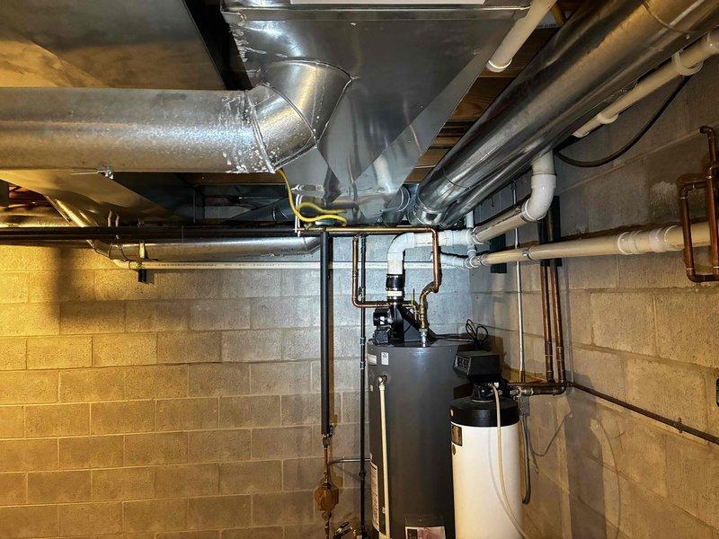 Responded to service call for fallen ductwork in basement utility area that had dropped approximately 6 inches, causing warping of water lines and gas piping. Technicians secured and lifted ductwork back to proper height, straightened 1" main gas piping with proper strapping, extended 1/2" gas piping to water heater, extended 1" copper pipes for hot and cold water connections to water heater, and repaired a loose PVC joint.