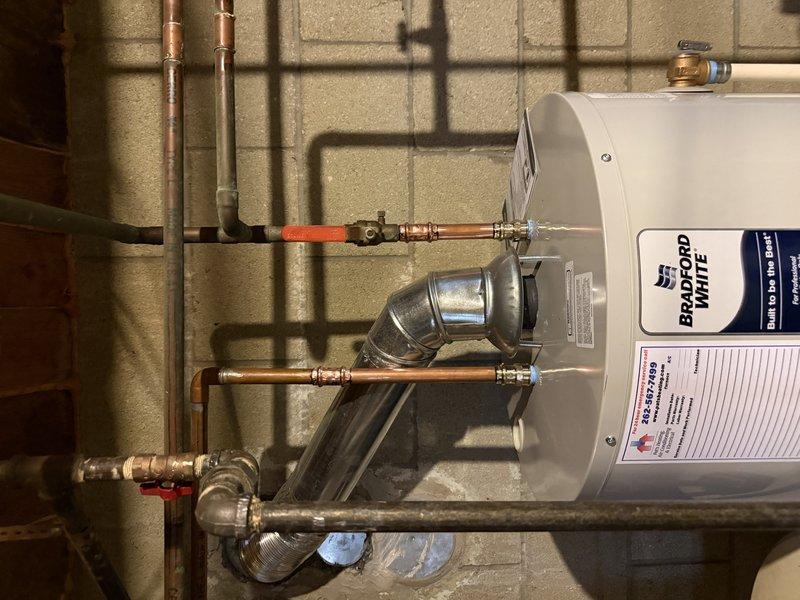 Successfully installed a 50-gallon Bradford White atmospheric natural gas water heater in utility room. Completed all required connections including copper water lines and proper ventilation. Verified proper ignition and flame quality through inspection port.