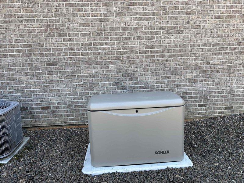 Installed a 26KW Kohler standby generator with two 200-amp RXT automatic transfer switches to provide backup power for the residence. Set concrete pad for generator placement, positioned unit against exterior brick wall with proper clearances, completed all electrical connections and gas line hookup to existing meter assembly, and restored decorative rock landscaping around installation area. Unit ready for final registration and commissioning test per promotional timeline.