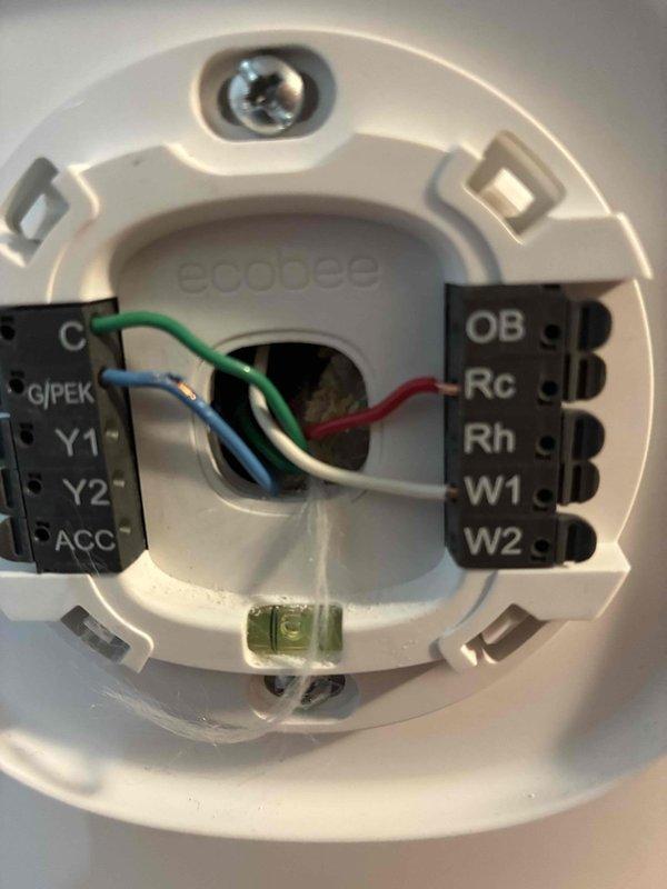 Responded to callback for air conditioner activating for 15 seconds when heating system engages. Inspected ecobee thermostat wiring and terminal connections at wall base and equipment. Addressed wiring compatibility issues between new thermostat and air conditioning system by installing new wire adapter to resolve improper system communication causing simultaneous heating and cooling calls.