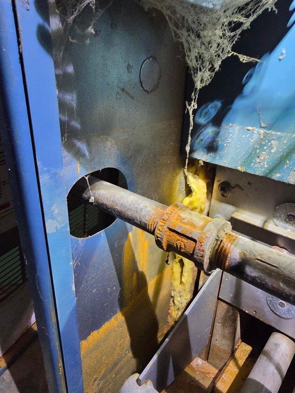 Performed post-flooding inspection on boiler and furnace system. Upon arrival, found extensive water damage with significant debris accumulation, including fibrous material buildup throughout mechanical components and visible corrosion on piping and connections. Inspected boiler cabinet, pressure gauge, valve assemblies, and associated piping for water damage and operational integrity. Documented equipment condition with photos showing rust formation on threaded connections, paint deterioration on cabinet surfaces, and potential contamination around pipe entry points. System components showed signs of extended service without recent maintenance, compounded by flood-related debris and moisture exposure.