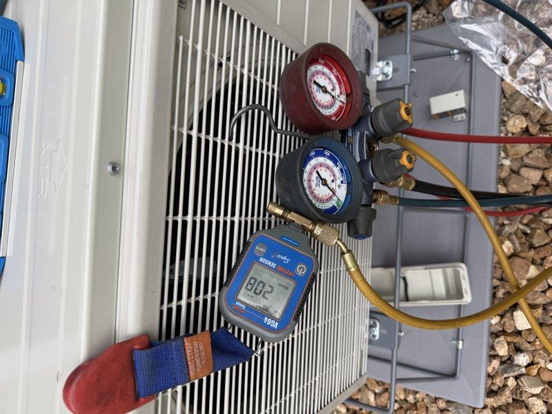 Completed new mini split system installation including outdoor condenser unit and indoor wall-mounted air handler. Installed refrigerant lines with proper insulation, established electrical connections, and charged system to manufacturer specifications. Verified system operation with manifold gauges and digital thermometer, confirming proper pressures and temperatures at 80.2°F. Indoor unit mounted in living area with decorative integration near windows and existing wood paneling. All components tested and operational upon completion.