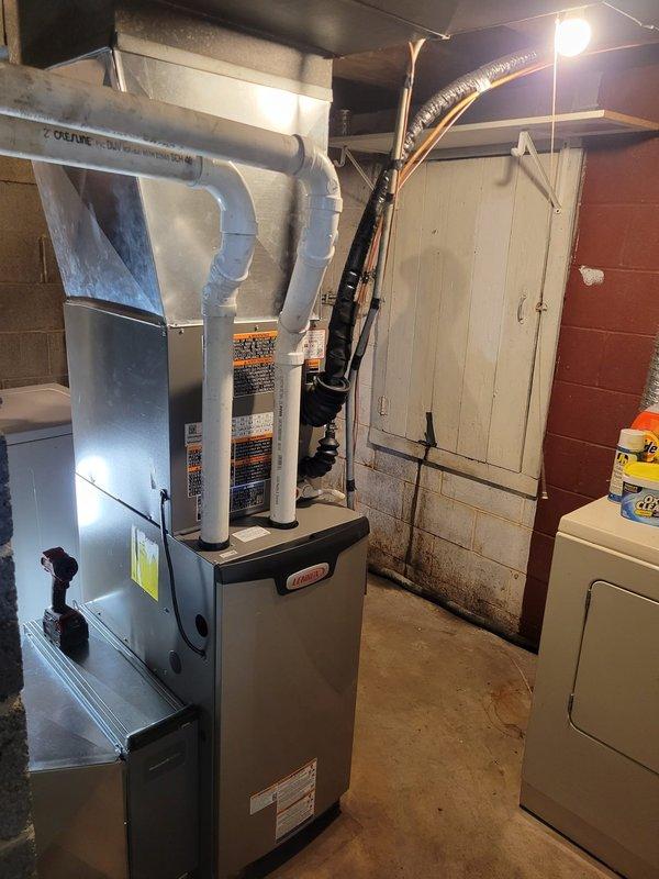 Completed full HVAC system replacement involving oil-to-gas conversion in residential basement. Installed EL297V 70,000 BTU gas furnace, EL15KC1 2-ton air conditioning unit, and 24B-71 evaporator coil to replace aging oil heating system. New gas piping was run and is awaiting utility company connection for final hookup. Electrical contractor was scheduled separately to complete AC wiring as this is a new air conditioning installation with no existing equipment. PVC venting system installed for high-efficiency furnace exhaust and intake. System is mechanically complete pending gas service activation and electrical work completion for air conditioning operation.