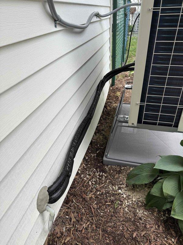 Installed Daikin 1.5 ton cold climate heat pump mini split system in 305 square foot room with three exterior walls, seven windows, and sliding patio door on southwest side of home. Mounted indoor evaporator unit on east wall shared with garage, routed refrigerant line set, condensate drain, and communication wiring through garage wall and exited south side to outdoor condenser location. Connected electrical power by repurposing unused welder circuit from garage subpanel, ran conduit through attic access and down interior garage wall to outdoor unit. Secured refrigerant lines along foundation with proper mounting brackets, installed outdoor unit on equipment pad, completed all electrical connections, tested system operation and confirmed proper heating and cooling functionality.