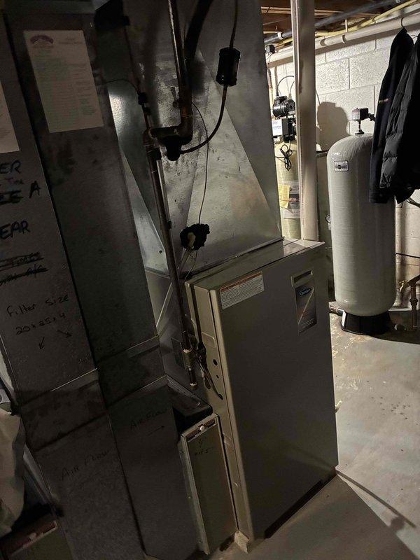 Responded to service call for air conditioning system not blowing cold air and making unusual noise. Upon arrival, performed diagnostic inspection of HVAC system located in basement utility area. Assessed furnace and air handler assembly, inspected ductwork connections, and examined refrigerant lines for potential issues. Documented equipment condition through photographic record showing furnace unit with attached plenum assembly and metal ductwork distribution system. Contacted customer by phone to provide diagnosis and discuss findings regarding cooling system malfunction and noise concern. Customer authorized payment by phone for diagnostic service performed.
