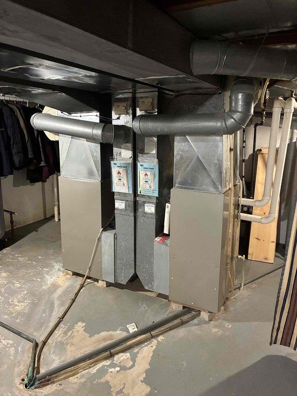 Responded to service call for air conditioning system not blowing cold air and making unusual noise. Upon arrival, performed diagnostic inspection of HVAC system located in basement utility area. Assessed furnace and air handler assembly, inspected ductwork connections, and examined refrigerant lines for potential issues. Documented equipment condition through photographic record showing furnace unit with attached plenum assembly and metal ductwork distribution system. Contacted customer by phone to provide diagnosis and discuss findings regarding cooling system malfunction and noise concern. Customer authorized payment by phone for diagnostic service performed.