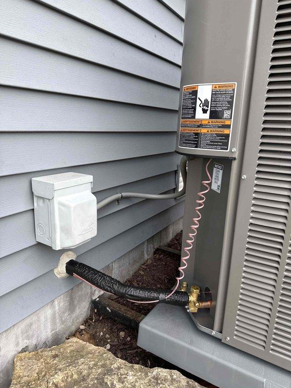 Successfully completed installation of Carrier ML14XC1 2.5 ton R410A air conditioning unit with matching 30B-01 cased evaporator coil for 1,700 square foot residence. Replaced existing 25-foot refrigerant line set, installed new condensing unit on pad positioned on existing brackets per specifications, and upgraded electrical disconnect with Square D QO 25-amp breaker. Sealed penetration point with spray foam insulation where line set exits structure. System was pressure tested, evacuated, charged to manufacturer specifications with R410A refrigerant, and verified operational with manifold gauges confirming proper pressures and temperatures.