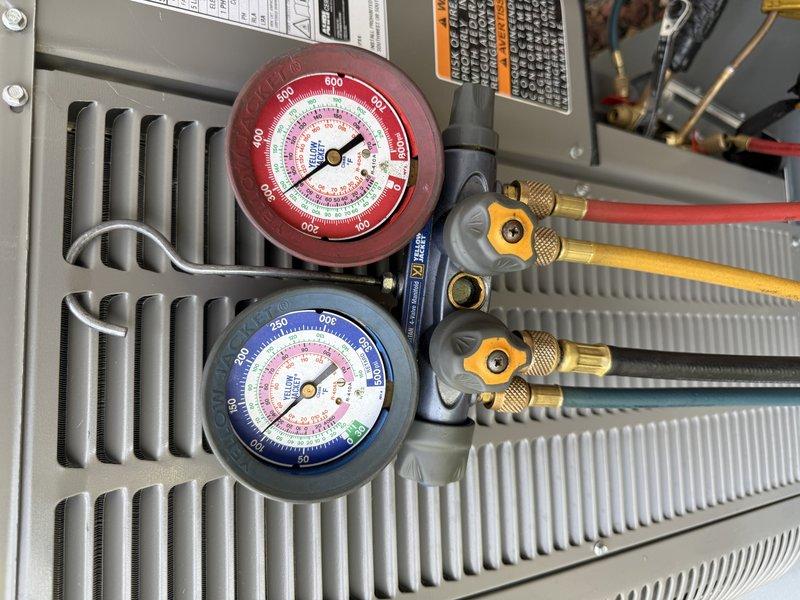 Responded to callback on recent HVAC installation where outdoor unit failed to start and produced clicking noise. Diagnosed system as overcharged with refrigerant, preventing proper compressor operation. Recovered 1.00 lbs of refrigerant using manifold gauge set to bring system to proper charge levels, verified pressures, and restored normal cooling operation.